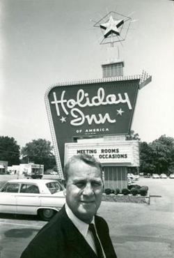 This undated photo shows company founder Kemmons Wilson standing outside the first Holiday Inn in Memphis, Tess.